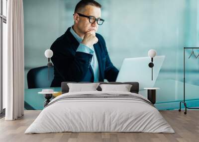 Senior man in modern office working on laptop computer Wall mural